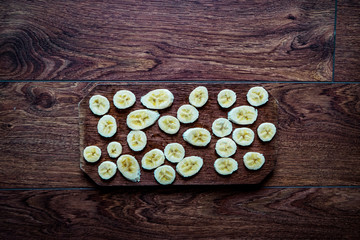 Fototapeta na wymiar slices of bananas on wood texture