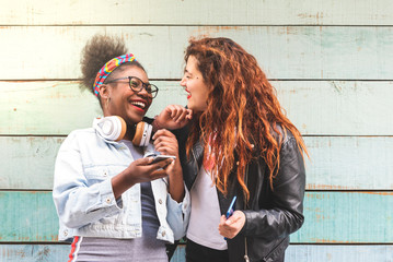 Multiracial Teenager Girls Using Mobile Phone Outdoors.