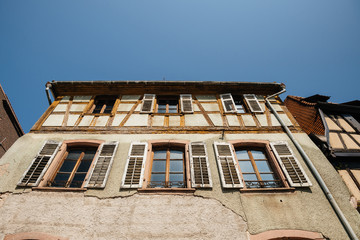 Fototapeta na wymiar Low angle view of vintage old half-timbered house in central of Alsatian village 