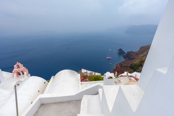 White houses of the village of Oia and the caldera on a rare rainy day