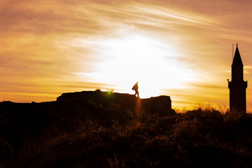 silhouette of a male tourist walking towards the summit next to the minaret
