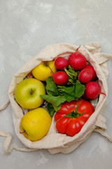 Cotton shopping bag with vegetables on grey bakground, zero waste concept. Image with copy space, flay lay.