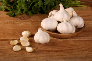Garlic Cloves and Bulb in vintage wooden plate on wooden table.