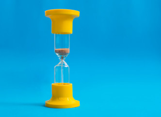 Yellow hourglass on blue background.