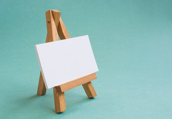 Wooden easel on a beautiful colored background.