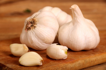 Garlic. sliced garlic, garlic clove, garlic bulb in wooden bowl place on chopping block on vintage wooden background.