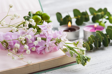 Open notepad with flowers and candles