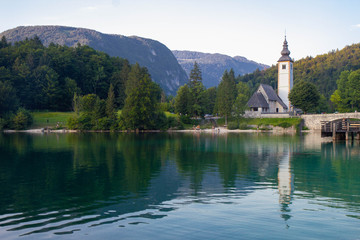 Fototapeta na wymiar Bohinj Lake, Church of St John the Baptist with bridge. Triglav National Park, Julian Alps, Slovenia
