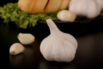 Tasty bread with Garlic. sliced garlic, garlic clove, garlic bulb, on kitchen black table.