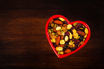 Energy Blend Trail Mix with Nuts and Dried Fruits in Heart Shaped Bowl. Selective focus.