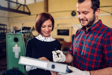 Worker at manufacturing factory signing document