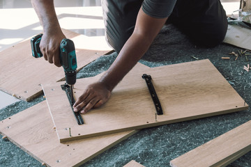 The carpenter is assembling the cabinet.