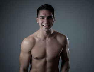 Fototapeta premium Portrait of strong handsome Athletic man feeling good and happy isolated on neutral background