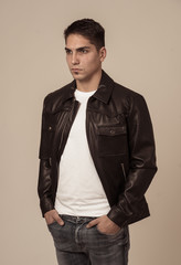 Fototapeta premium Fashion portrait of Attractive young mixed race man model posing in leather jacket.