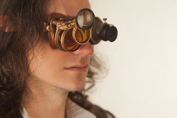 Vintage style researcher mechanist of the monocle with a large number of lenses looking at something