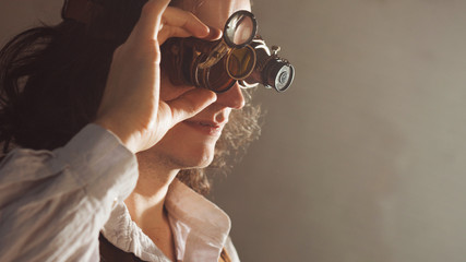 Vintage style researcher mechanist of the monocle with a large number of lenses looking at something