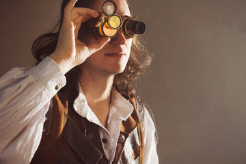 Steampunk style researcher mechanist of the monocle with a large number of lenses looking at...