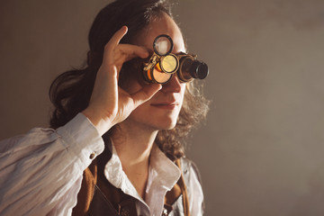 Steampunk style researcher mechanist of the monocle with a large number of lenses looking at...