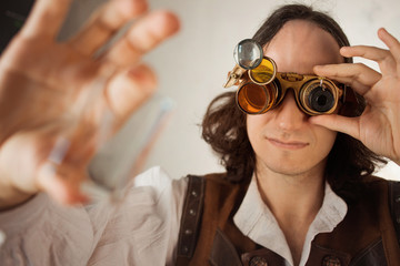 Steampunk style researcher mechanist of the monocle with a large number of lenses looking at...