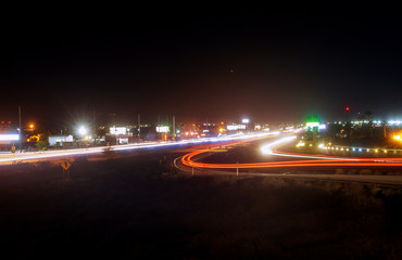 Fototapeta na wymiar Speed traffic light highway at night, long exposure abstract urban background