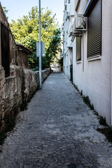 a narrow urban street with stone floors and old vintage buildings