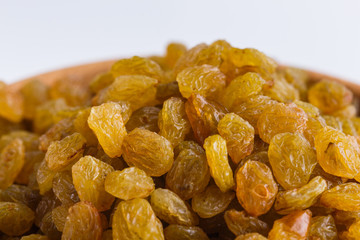 golden raisins on a white acrylic background