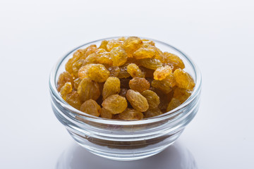 golden raisins on a white acrylic background