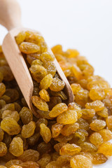 golden raisins on a white acrylic background