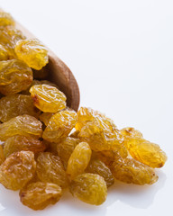 golden raisins on a white acrylic background