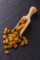 golden raisins on a dark stone background