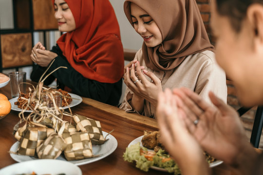 muslim man and woman praying together before having their food in ramadan day