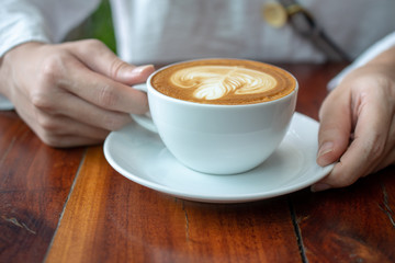 People are drinking a latte in a coffee shop.