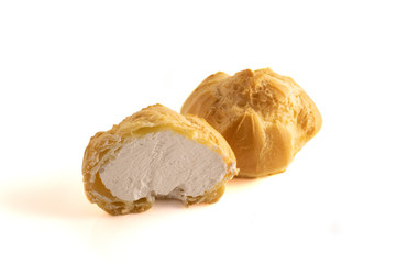 Close up view of eclair with cream. Cut in half filled profiterole with vanilla cream .Traditional French dessert.