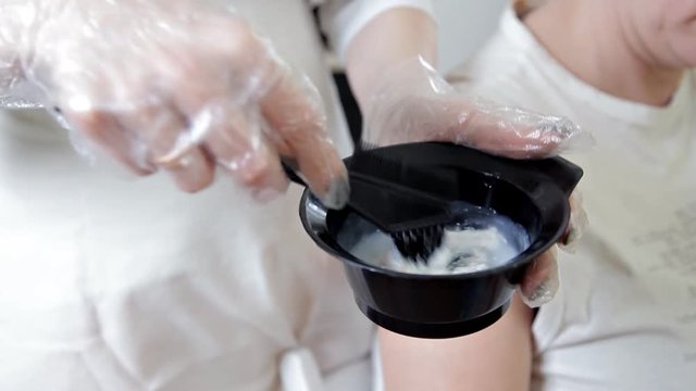 A hairdresser mixing a hair dye in a bowl, prepare the paint for the hair