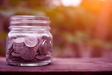 Obraz na płótnie Canvas Thai Baht Coins Money in Jar on Wooden Table