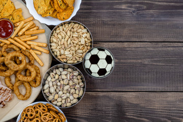 Mix of snacks with beer with a soccer ball on a beer foam. Top view, Empty space for text