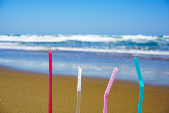 Plastic straw on sandy beach. Marine pollution image. 砂浜にあるプラスストロー　海洋汚染のイメージ