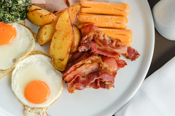Breakfast consists of eggs, bacon, sausage, bacon, potato and spinach with cheese. delicious on the morning
