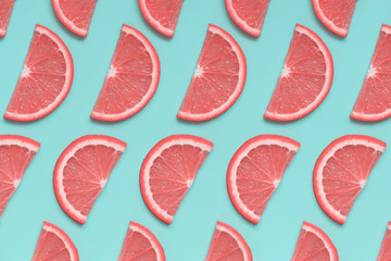 Pink grapefruit isoetric pattern on pastel blue background. Minimal summer fruit concept, pop art style. Flat lay, top view.