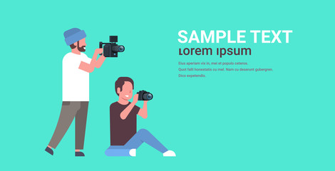 photographer and cameraman using cameras shooting video taking pictures working together teamwork during studio session horizontal full length flat copy space