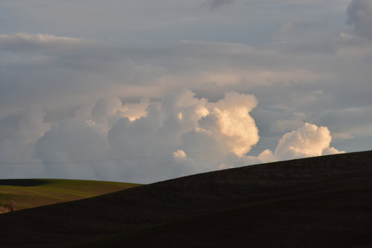 Billowing clouds over rolling hills