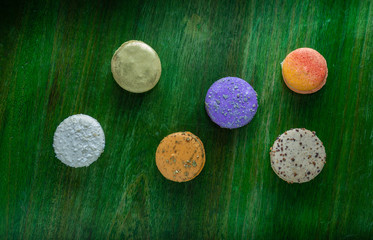 Colorful macaroons on a green wooden table