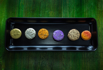 Colorful macaroons on black plate