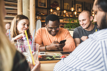 Meet young attractive people in the cafe. Friends chat, have fun, drink cocktails and eat