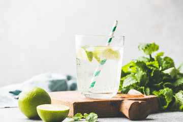Sparkling summer cocktail with lime and mint or soda water with lime. Ice cold refreshing summer...