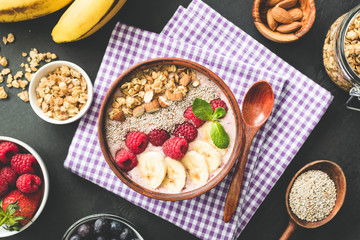 Smoothie bowl topped with berries, granola and chia seeds. Healthy vegan, vegetarian food. Top view, toned image