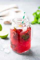 Red berry summer cocktail or ice tea in jar. Ice cold beverage. Vertical orientation
