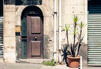 Entrance door, facade of old baroque building in Catania, traditional architecture of Sicily, Italy.