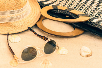 Straw hat, bag and sun glasses on a tropical beach .