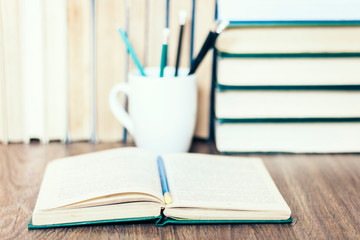 Stack of books, pencils, open book, glasses, background for education learning concept.